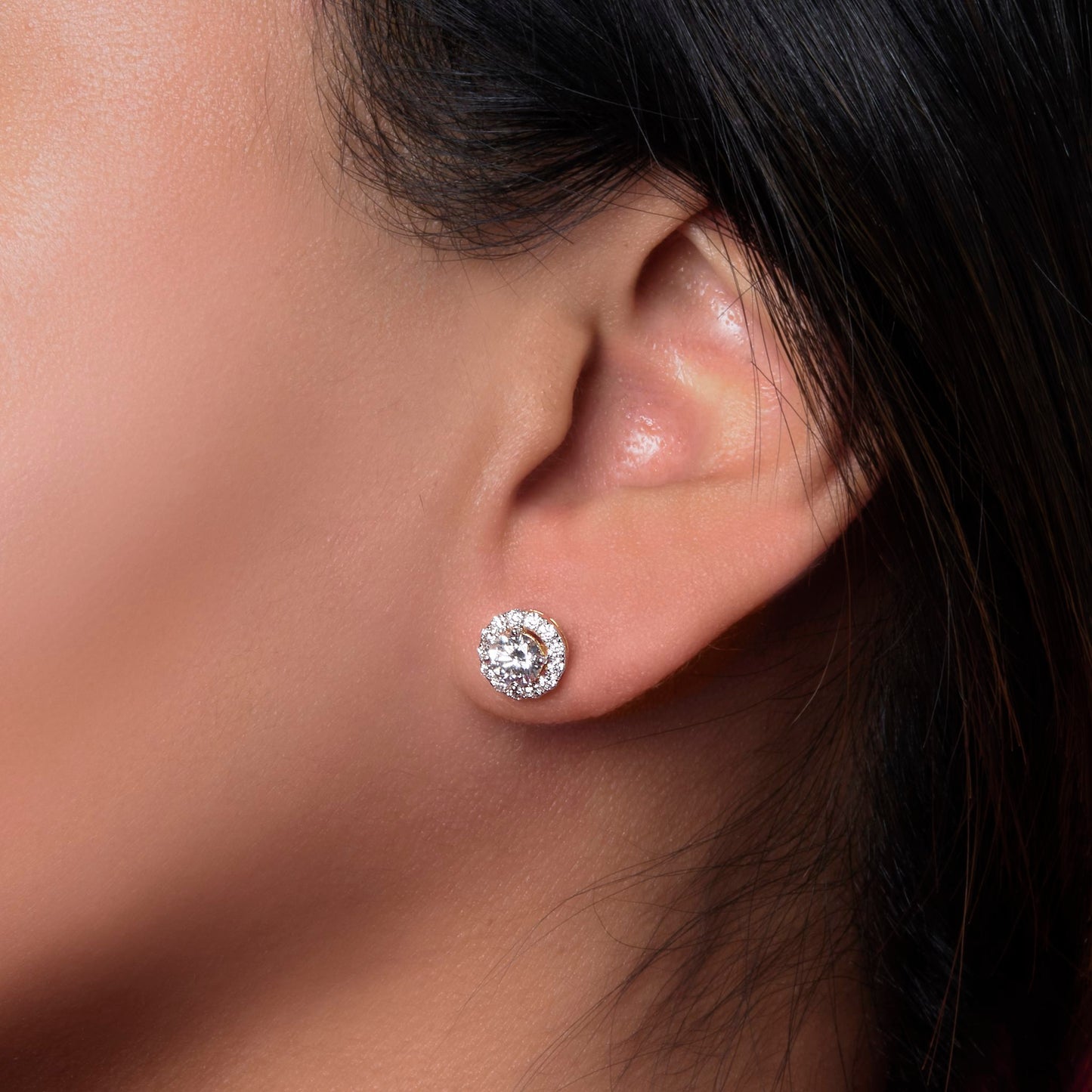 Close-up lifestyle shot of Lumeniri halo diamond studs sparkling on ear timeless fine jewelry style