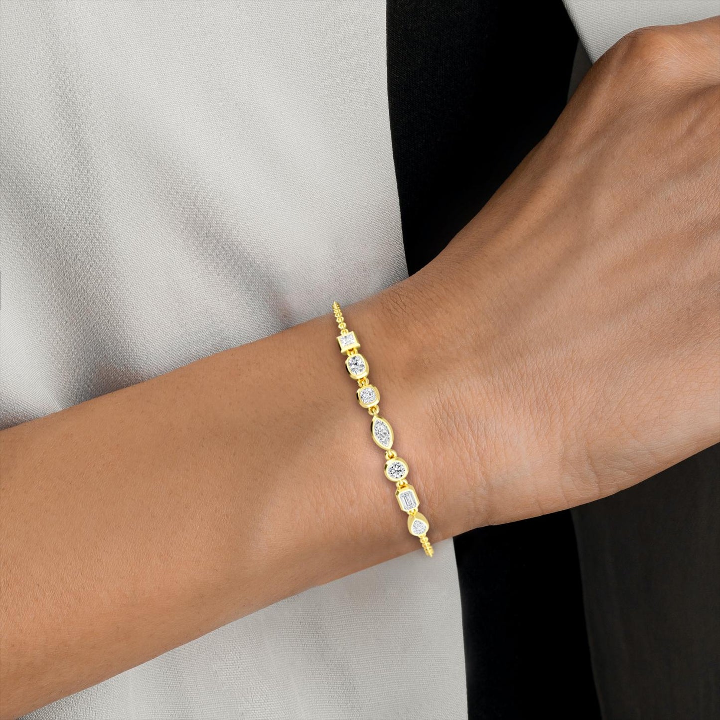 Delicate Lumeniri Isadora bracelet with seven bezel-set mixed shape lab grown diamonds in polished 14K yellow gold