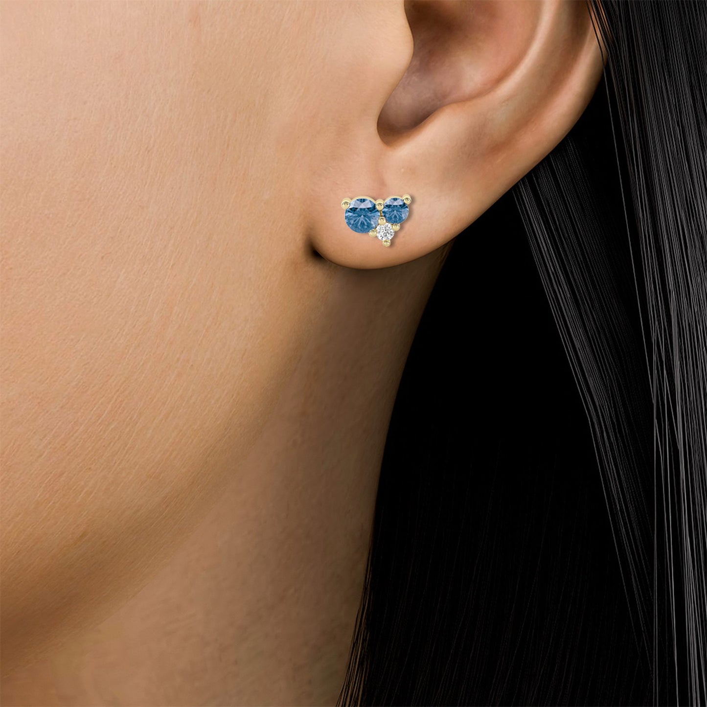 Lumeniri Celeste Collection Blue LGD Cluster Stud Earrings worn on ear, featuring 0.73ct of white and blue lab-grown diamonds set in 14K yellow gold, offering a sophisticated and sustainable luxury look.