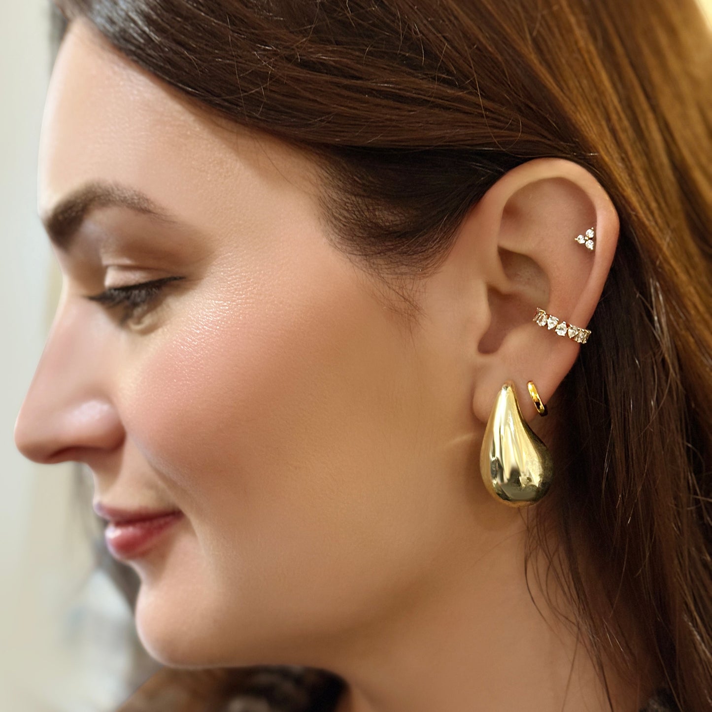 Lumeniri The Kelli Trilogy Stud Earrings worn on ear, displaying 0.30ctw of lab-grown diamonds in 14K Yellow Gold, a perfect blend of sophistication and sustainability.