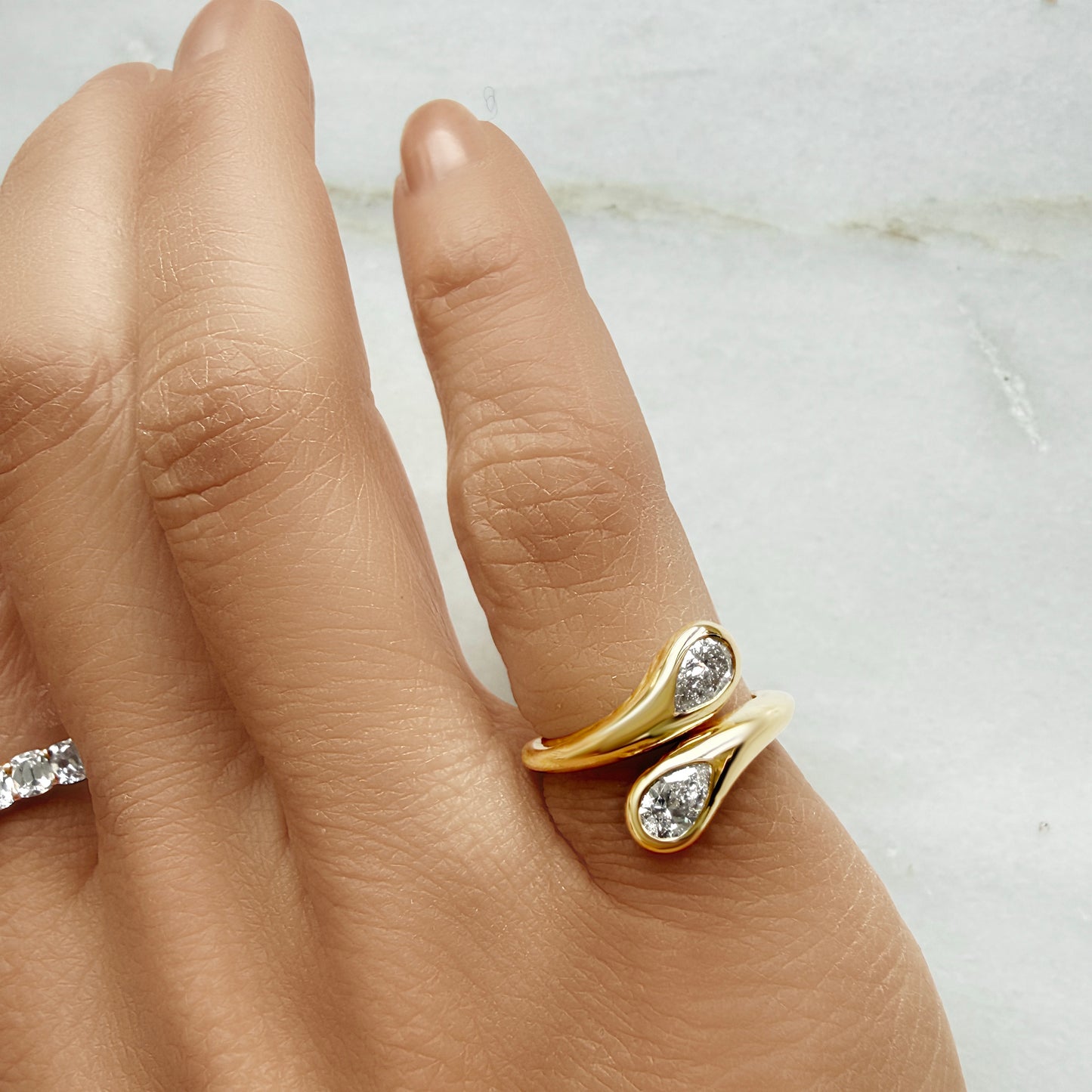 Lumeniri The Nagas Pinky Ring worn on hand, showcasing dual pear shaped 0.52ct IGI certified lab grown diamonds in sculptural open wrap 14K gold design, modern fine jewelry styling.