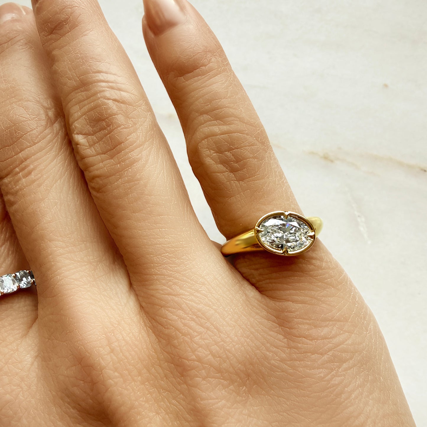 Lumeniri The Valora Pinky Ring worn on hand, showcasing 1.04ct oval lab grown diamond in EF VS clarity, sculptural chunky band 14K gold design with modern bezel and claw prongs, elegant fine jewelry styling.