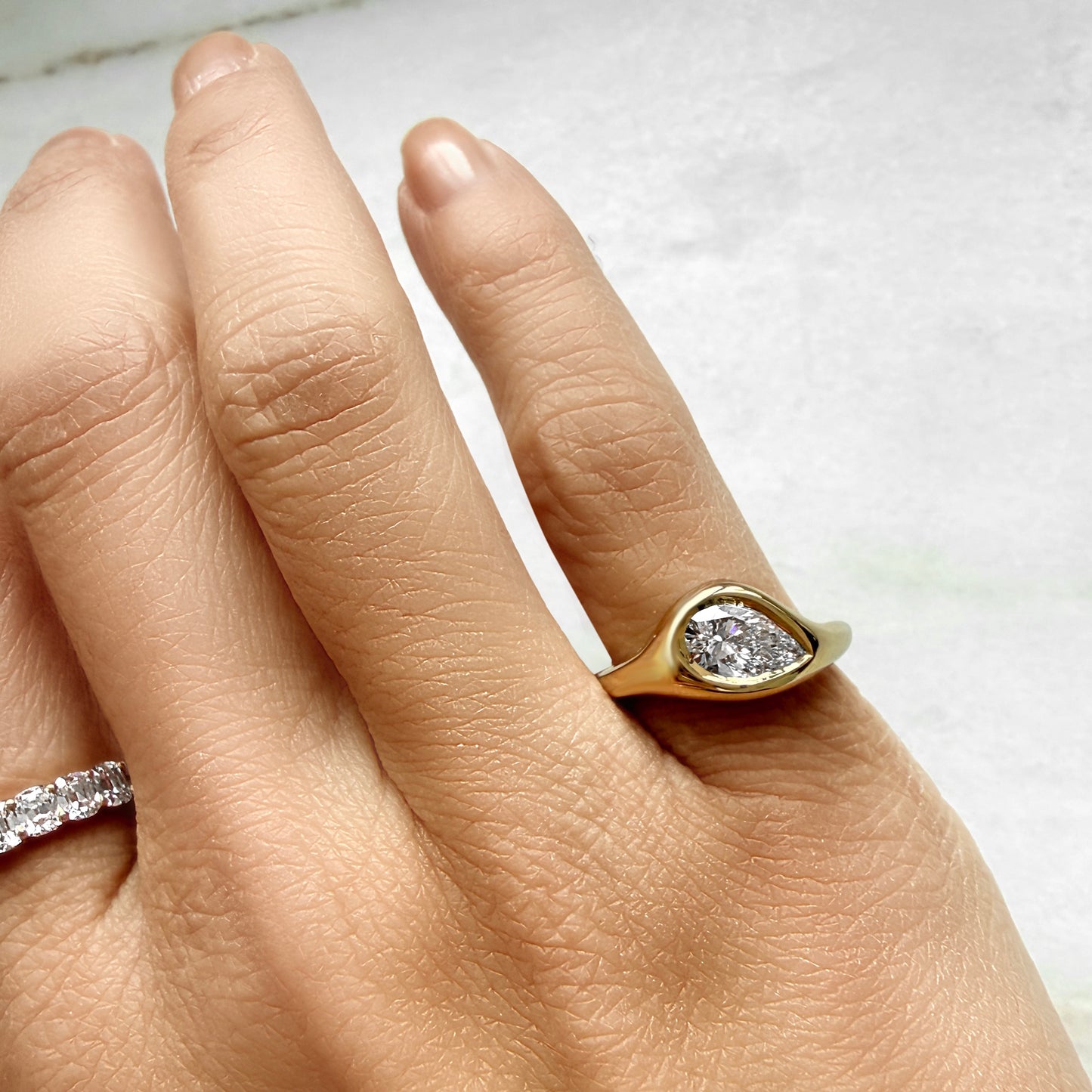 Lumeniri The Zaria Pinky Ring worn on hand, showcasing 1.08ct pear shaped IGI certified lab grown diamond in sculptural bubble band 14K gold design, bold modern fine jewelry styling.