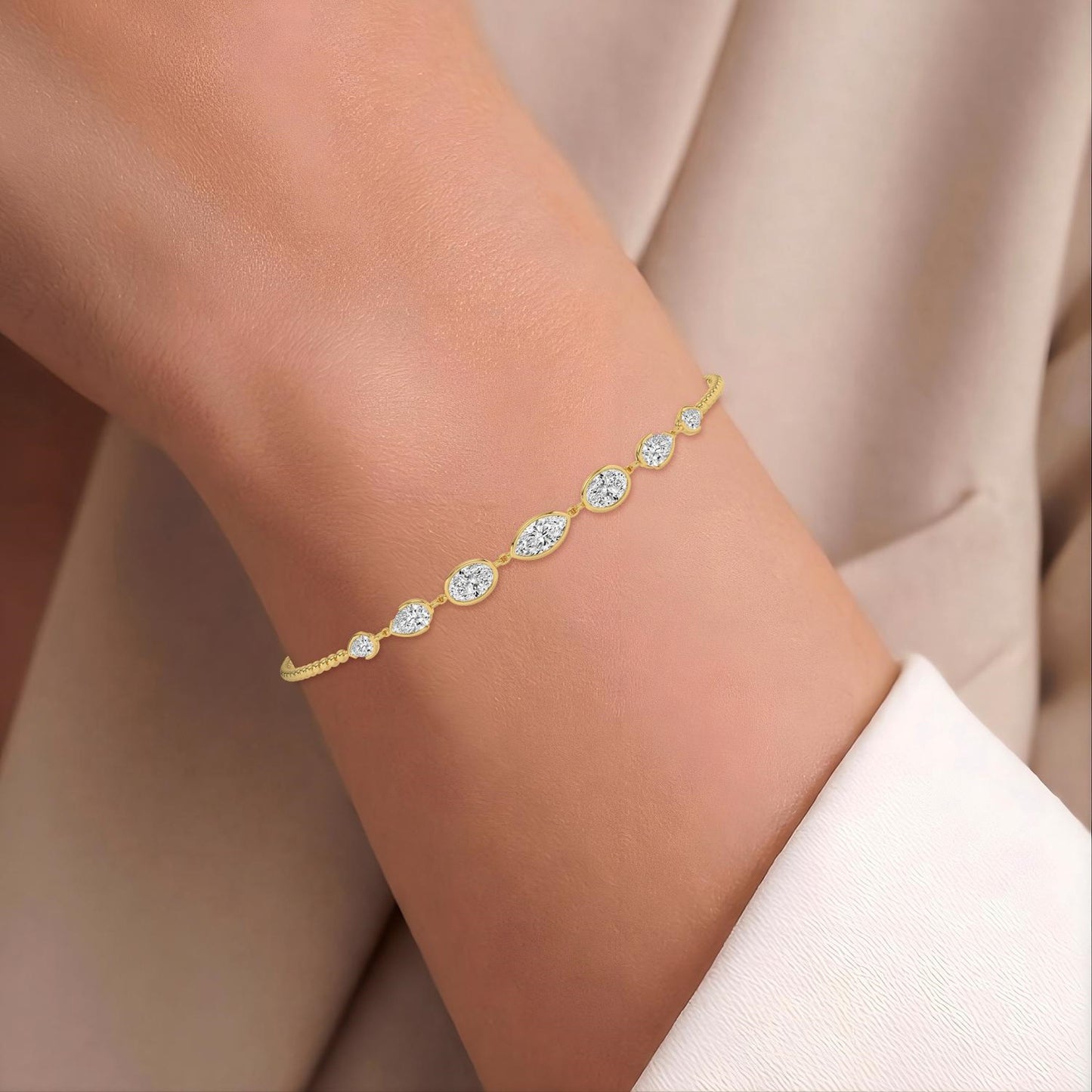 Lumeniri lab grown diamond bracelet showcasing seven bezel-set mixed shape stones on adjustable yellow gold chain