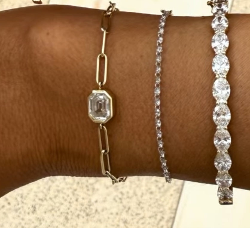 Model wearing the Dipti Emerald Step Cut Solitaire Paperclip Bracelet in 14K, showcasing the 0.5ct EF color, VS clarity diamond against the wrist