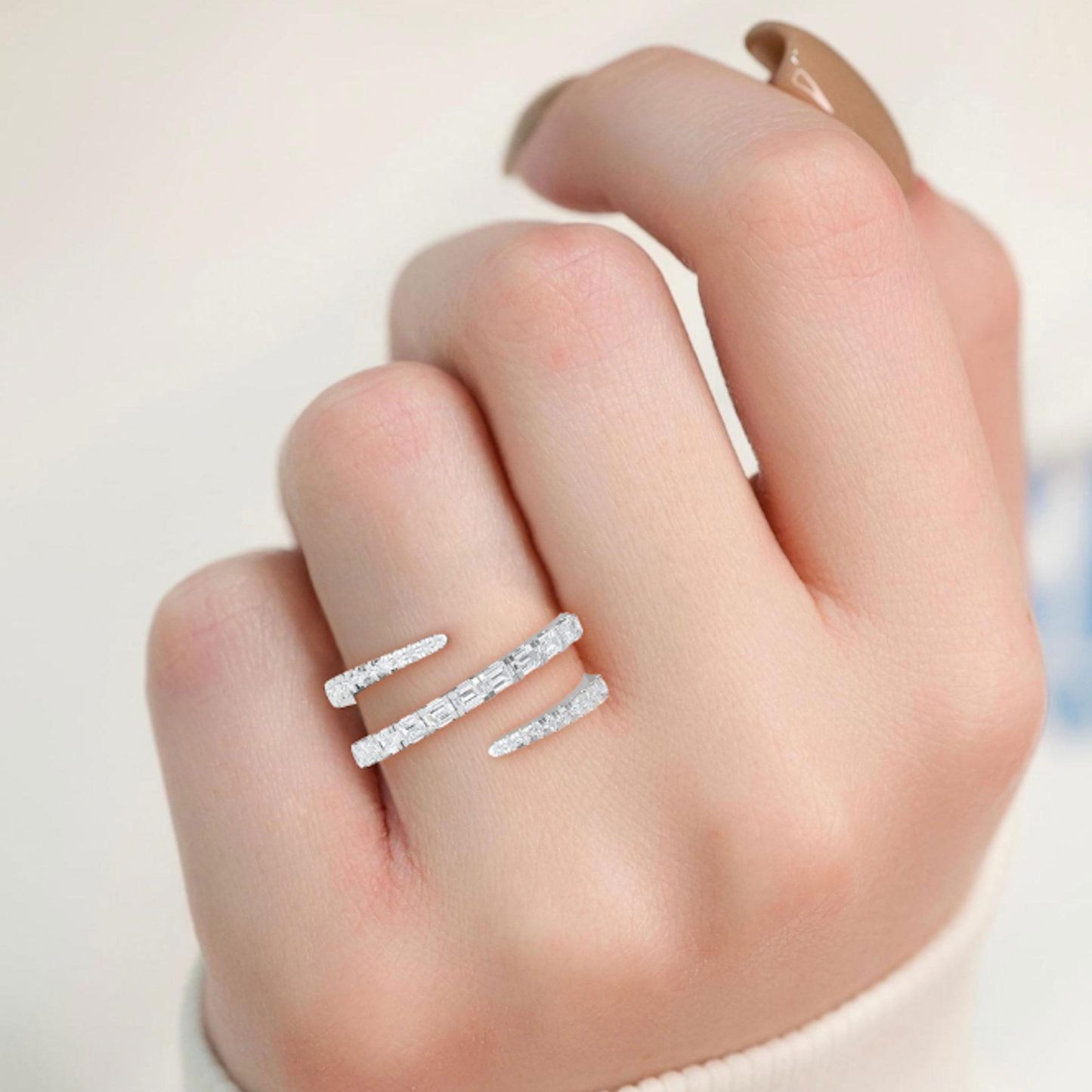 Model wearing the Kenzie Coil Ring, front view showcasing the wraparound band with round and baguette lab-grown diamonds in 14K white gold