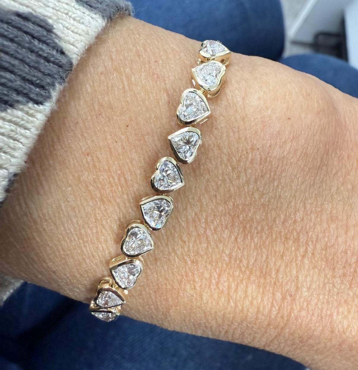 Model wearing the Lucia Heart Half Tennis Chain Bracelet in 14K yellow gold, showcasing 2.0ct EF color, VS clarity heart and round lab-grown diamonds on wrist